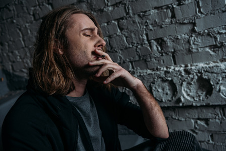 close-up portrait of young man smoking cigaretteの写真素材