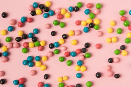 close up view of various candies isolated on pink