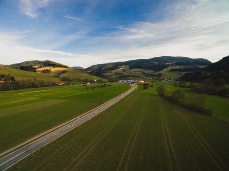 Aerial view of spectacular landscape with road, blue sky and green field, Germanyの写真素材