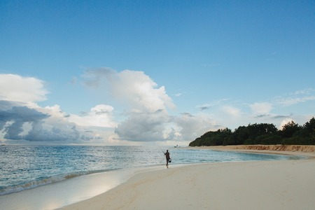 THODDOO ISLAND, MALDIVES -  27 JANUARY, 2018: unrecognizable fisherman walking on sandy beach at Thoddoo island, Maldivesのeditorial素材