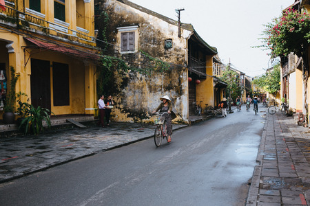 HOI AN, VIETNAM - 03 JANUARY, 2018: people in traditional hats riding bicycles on street in Hoi An, Vietnamのeditorial素材