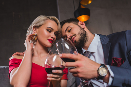 sensual stylish young couple drinking red wine togetherの写真素材