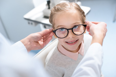 oculist and little child in glasses in optical clinicの写真素材