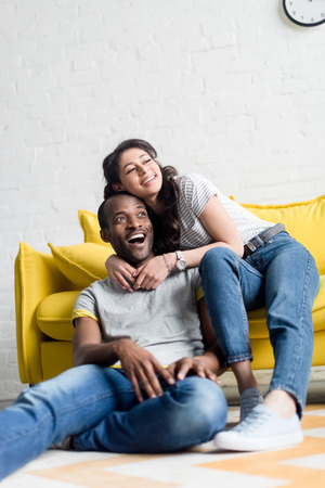 Beautiful African american couple spending time together at living roomの写真素材