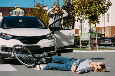 Young woman mowed down by driver in car on road, car accident conceptの写真素材