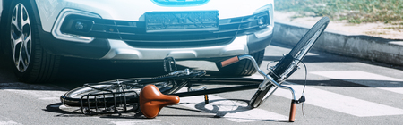 Close up view of broken bicycle and car on road, car accident conceptの写真素材