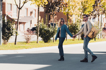 Couple holding hands while walking together in new cityの写真素材