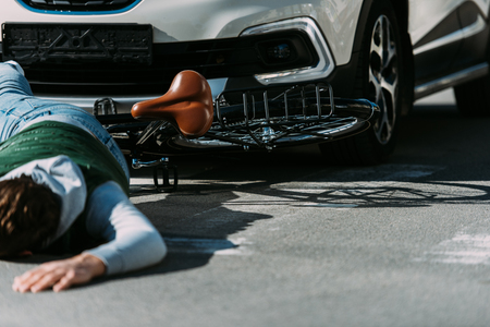 Partial view of male bicycle rider hit by car on road, car accident conceptの写真素材