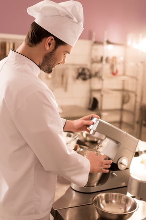 Side view of confectioner cooking dessert in restaurant kitchenの写真素材