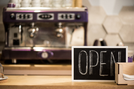 Selective focus of open blackboard on wooden counter in cafeの写真素材