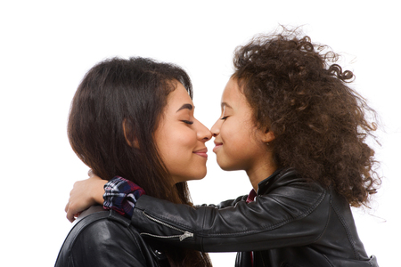 Close-up shot of cuddling happy mother and daughter isolated on whiteの写真素材