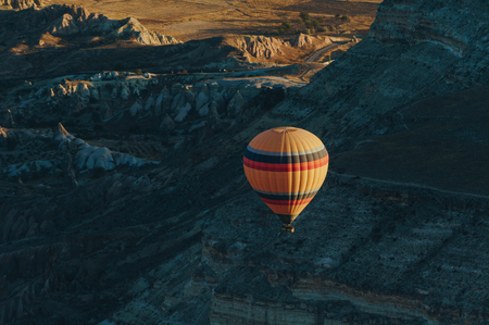 One Hot air balloon flying in Goreme national park, fairy chimneys, Cappadocia, Turkeyの写真素材