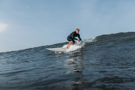 surfer riding wave on surf board in ocean