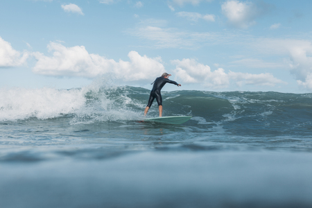 male surfer riding wave on surf board in oceanの写真素材