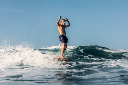 Active surfer having fun and riding wave in oceanの写真素材