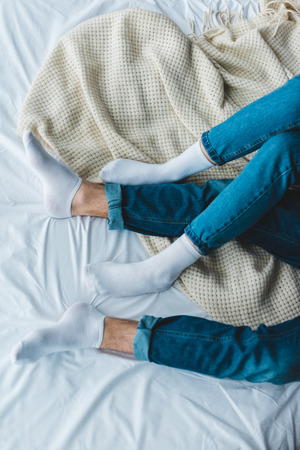 Partial view of young couple lying on bedの写真素材