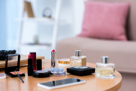 close-up view of smartphone and various cosmetics on tableの写真素材