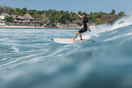 Surfer riding wave on surf board in oceanの写真素材