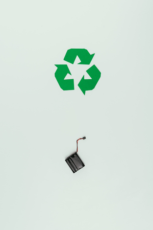 Top view of recycle sign and accumulator isolated on greyの写真素材