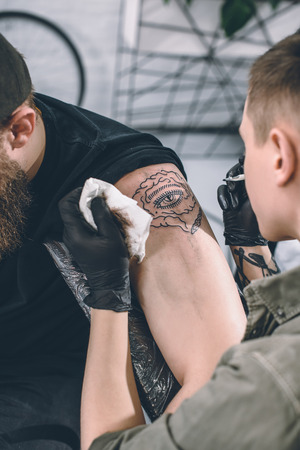 Tattoo artist working on shoulder piece in studioの写真素材