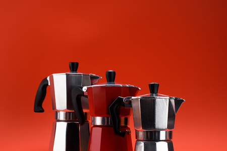 close up view of arrangement of coffee makers isolated on redの写真素材