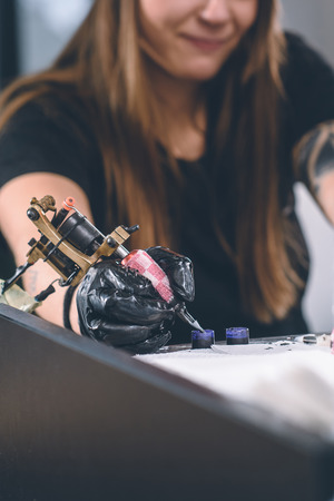 Cropped view of female tattoo artist working with inkの写真素材
