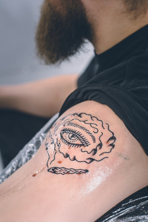 Male shoulder with new tattoo on itの写真素材