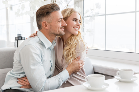 couple embracing spending time together in cafeの写真素材