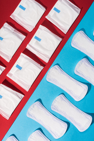 top view of rows of pads and daily liners on red and blueの写真素材