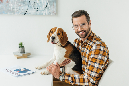 businessman holding cute beagle and looking at cameraの写真素材