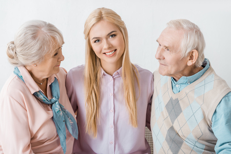 young smiling woman hugging senior parents