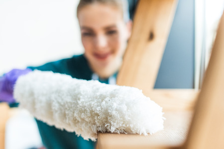 close-up view of young woman with duster cleaning homeの写真素材