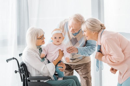 happy senior people playing with toddler in nursing home