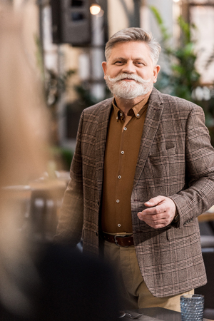 Selective focus of smiling senior man in cafeの写真素材