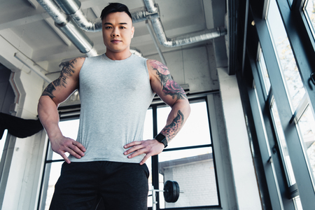 Low-angle shot of young Asian sportsman at gymの写真素材