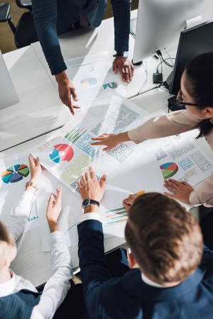 Cropped shot of young business team working with charts and graphs in officeの写真素材