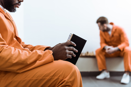 Cropped image of African american prisoner reading bookの写真素材