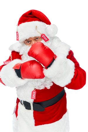 Santa Claus in boxing gloves and red costume with sale tags isolated on whiteの写真素材
