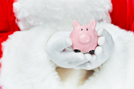 Cropped view of Santa Claus holding piggy bankの写真素材
