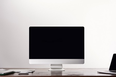 Monoblock computer with laptops on wooden table isolated on greyの写真素材