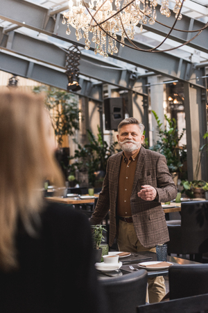 Selective focus of senior man looking at woman in cafeの写真素材