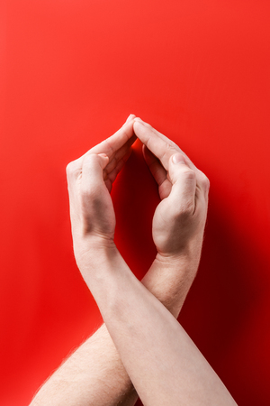 male hands showing aids awareness sign on red backgroundの写真素材