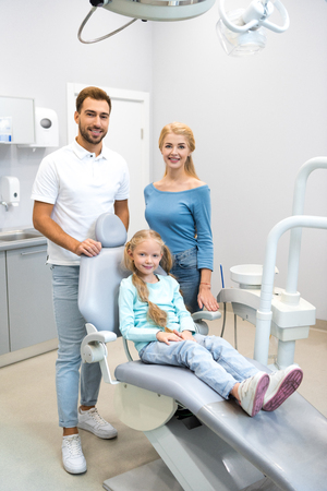 beautiful young family looking at camera at dentist officeの写真素材