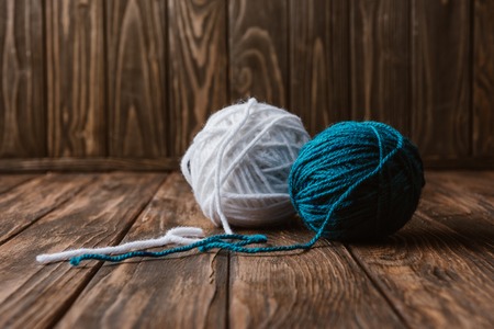 Close up view of white and blue yarn balls on wooden tabletopの写真素材