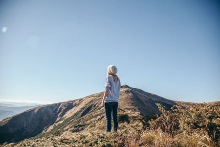 rear view of woman looking at mountains on sunny day, Carpathians, Ukraineの写真素材