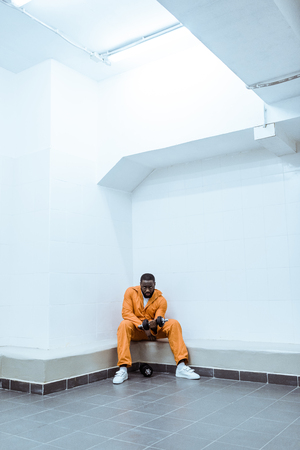 african american prisoner in light modern prison cellの写真素材