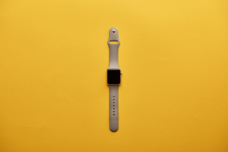 top view of smart watch with blank screen on yellow surfaceの写真素材
