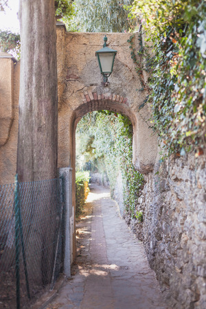 beautiful ancient arch with lantern on cozy street in Portovenere, Italyの写真素材