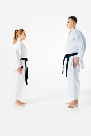 karate fighters standing and looking at each other isolated on whiteの写真素材