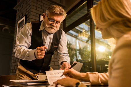 selective focus of businesswoman signing contract during meeting with colleague in caeの写真素材